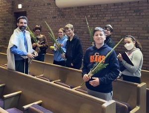 Religious school teenagers with Rabbi Glick in the synagogue.